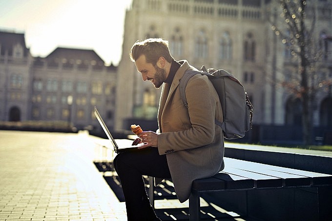 A man attends a meeting remotely while sitting on the street of Budapest, Hungary, May 2022. Photo: Andrea Piacquadio