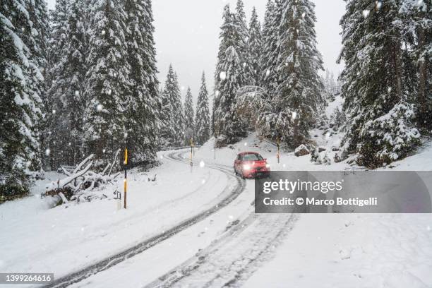 Car driving on a mountain snowy road during snowfall