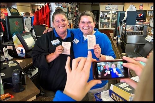 Kristi Williams, left, and Kelly Blount, both sales associates at the Trex Mart in Dearborn, Missouri, pose for a cell phone photograph, Thursday, November 29, 2012, holding a paper Powerball receipt stating one of the national winners purchased a winning