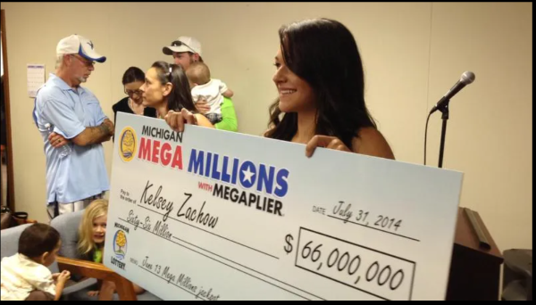 Kelsey Zachow, 24, of Port Huron holds a $66 million Mega Millions jackpot check. Zachow, along with her family, received the check in Sterling Heights.