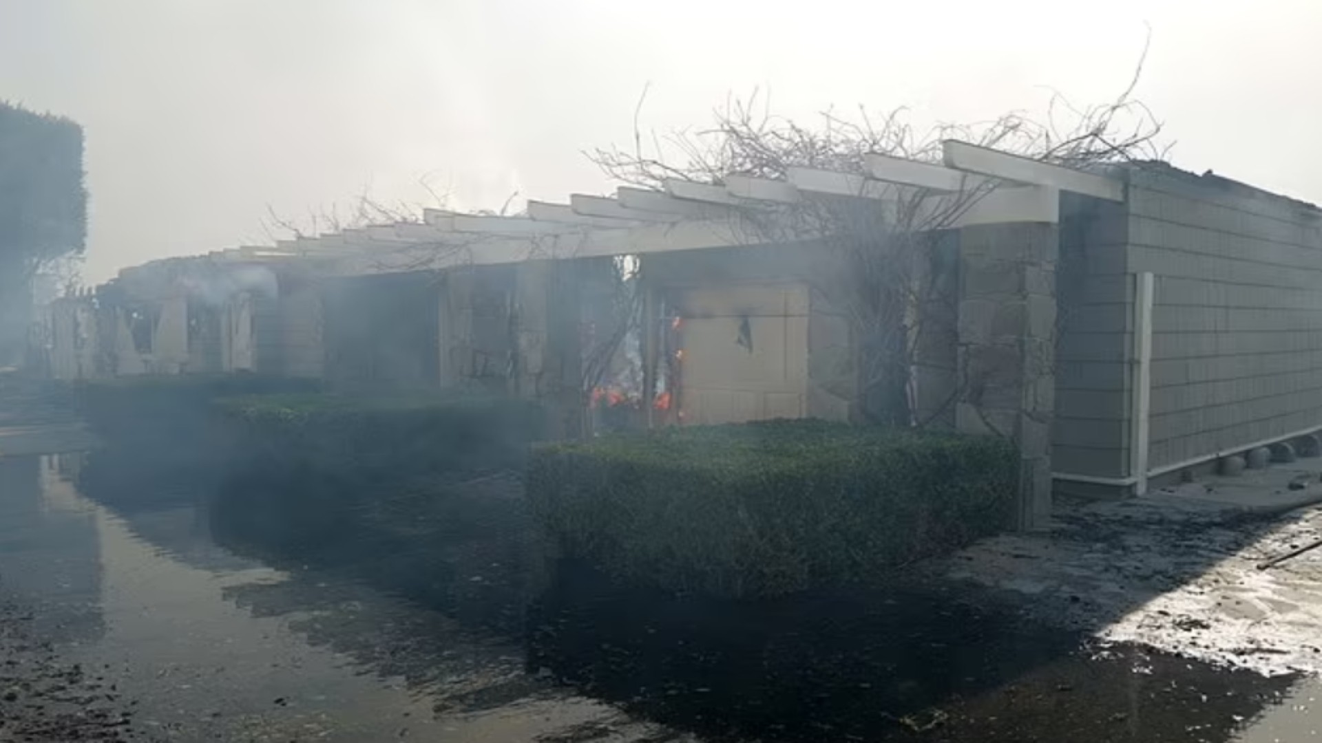 While many of the walls appear to be still standing, they are blackened from the flames with many parts of the home still on fire