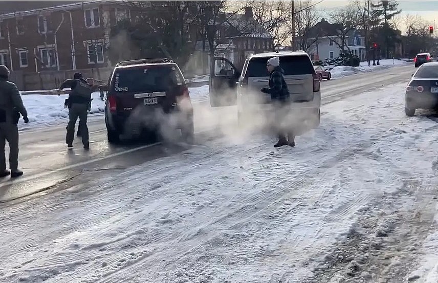 The ICE agent firing as the car pulls away The ICE agent firing as the car pulls away