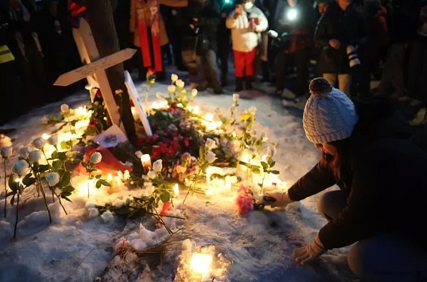 People gather at a makeshift memorial for Renee Good, 37, who was fatally shot by an ICE agent