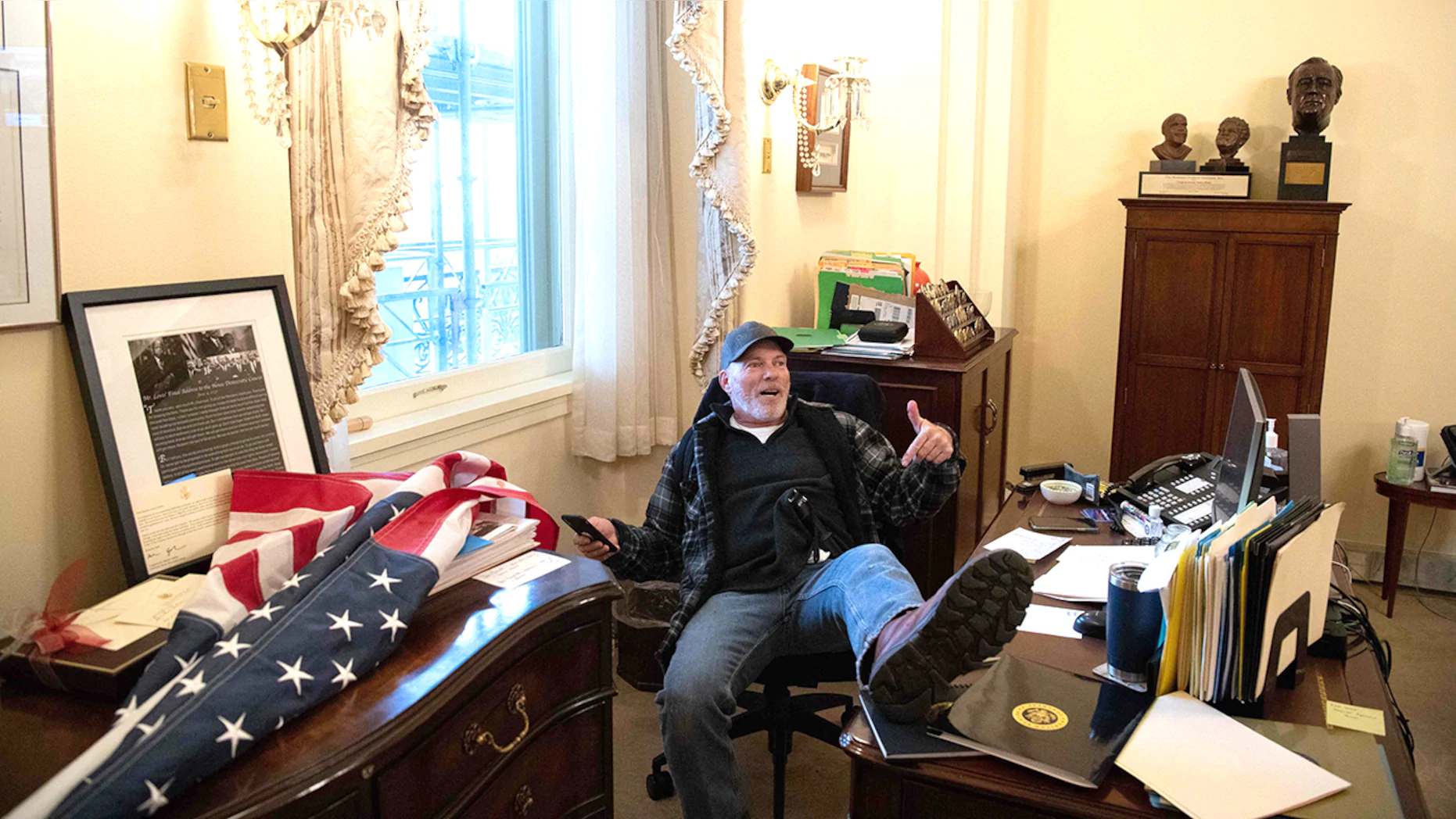 Richard Barnett, a supporter of U.S. President Donald Trump, sits inside the office of U.S. Speaker of the House Nancy Pelosi inside the U.S. Capitol in Washington, DC, on Jan. 6.  (Saul Loeb/AFP via Getty Images).