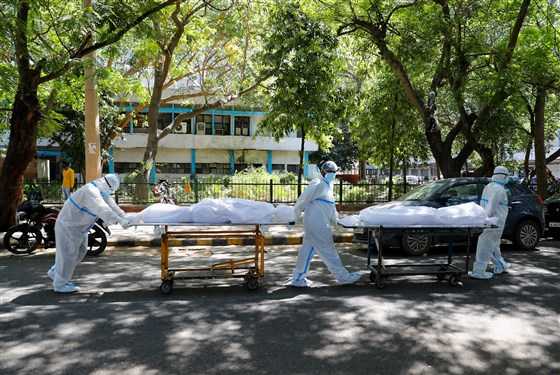 Health workers transport bodies of people who died with Covid-19 at Guru Teg Bahadur hospital in New Delhi on Saturday. Adnan Abidi / Reuters